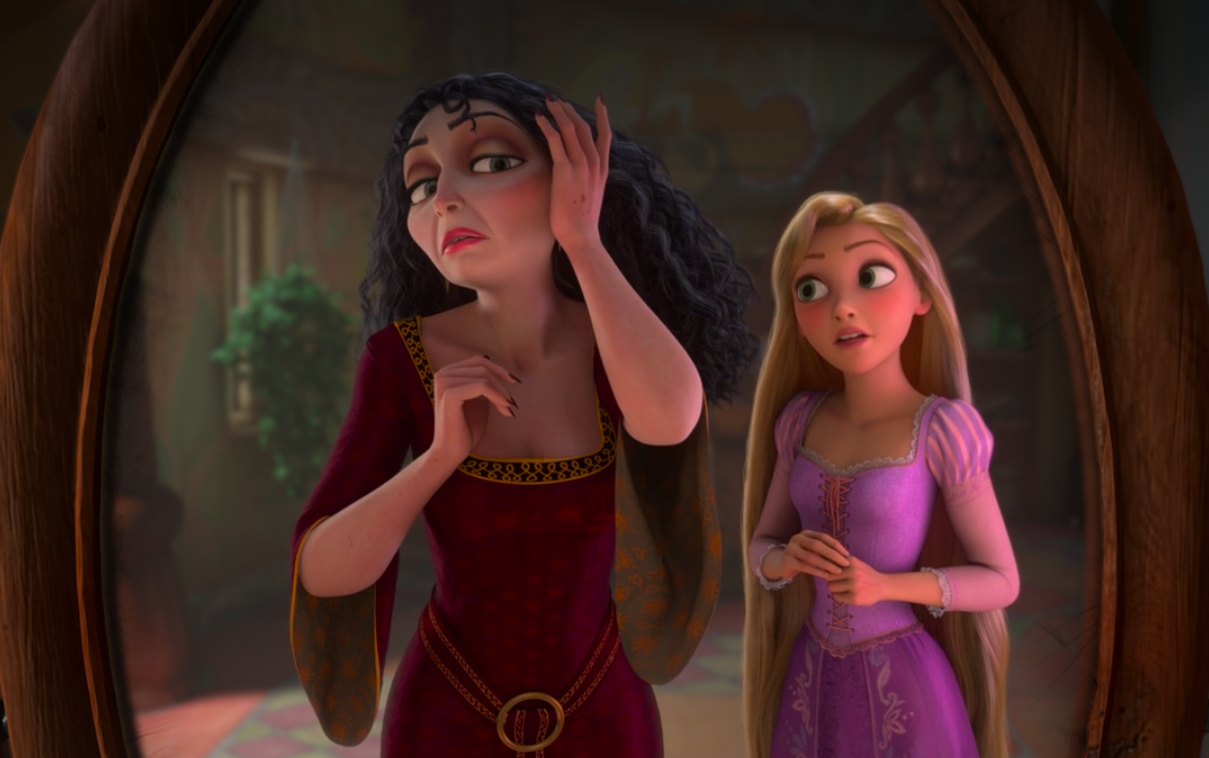 Mother Gothel gazes at herself in the mirror