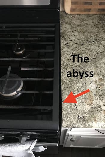 a reviewer photo of the point where the stove meets the countertop with a red arrow pointing at the gap and text reading 