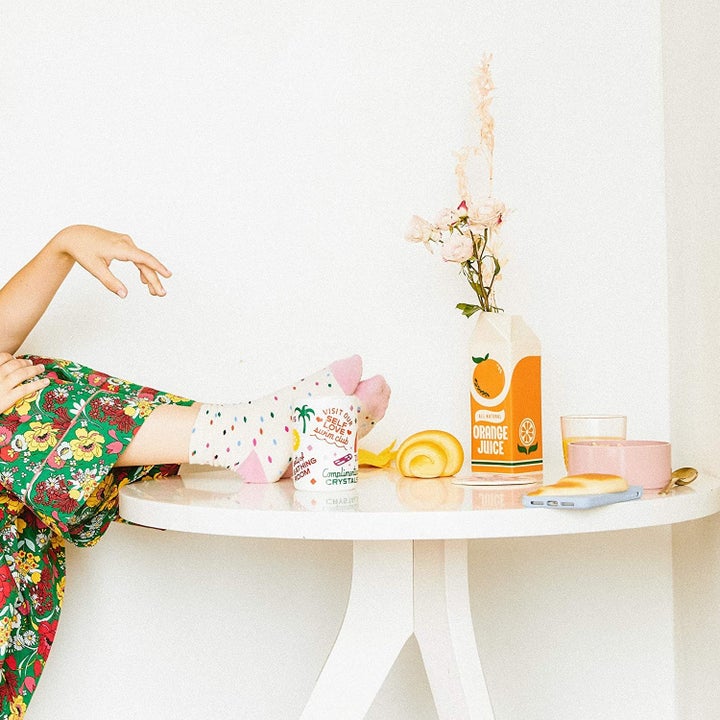 orange juice carton vase with a small amount of flowers placed on a table 