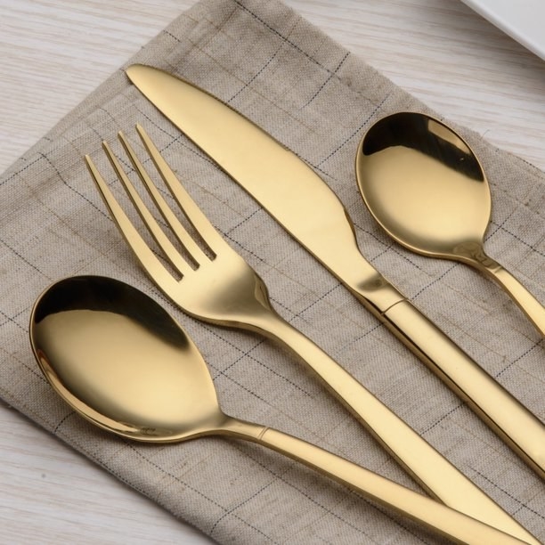 Four pieces of the flatware set on a cloth napkin.