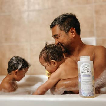 A parent and two kids enjoying a bubble bath