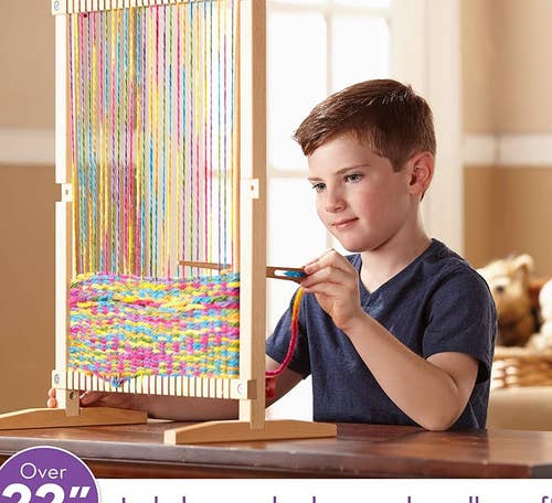 Child model playing with loom and colorful yarn