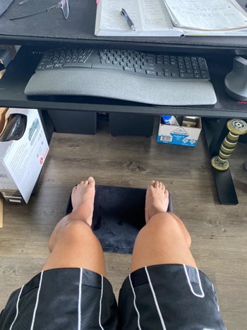 reviewer POV view of feet on foot rest under a home office desk