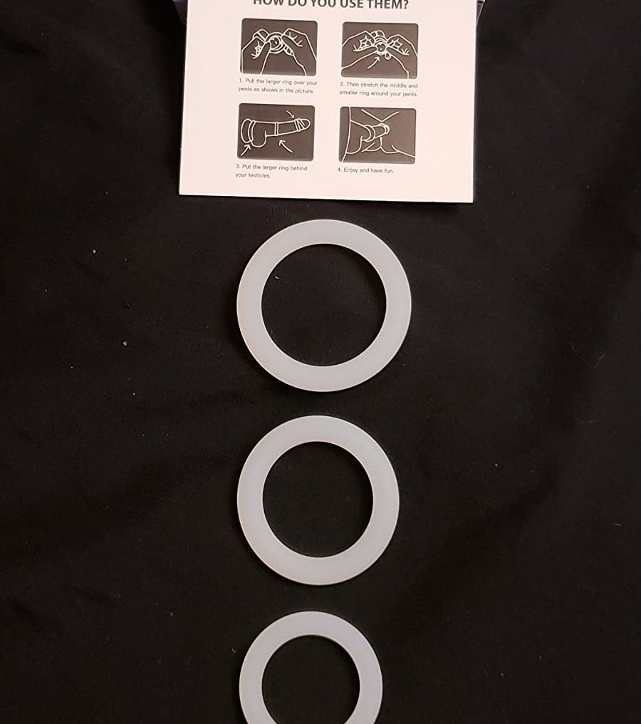 Three white cock rings arranged by size and compared to a quarter