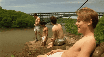 An object appears to fall of a bridge in the background of a scene with Dicaprio