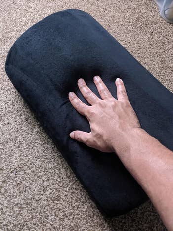 reviewer photo pressing hand on foot rest, showing how soft it is