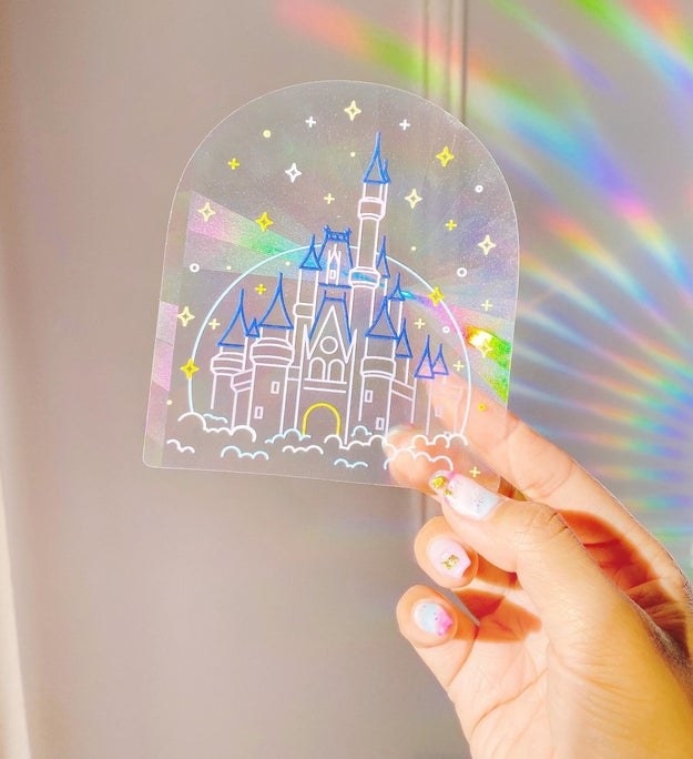 hand holds reflective sticker with Disney castle illustration on the front