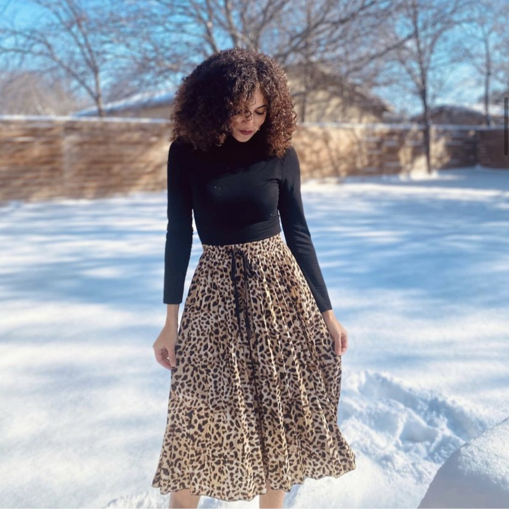 a reviewer photo wearing the black mock turtleneck bodysuit with a leopard print midi skirt