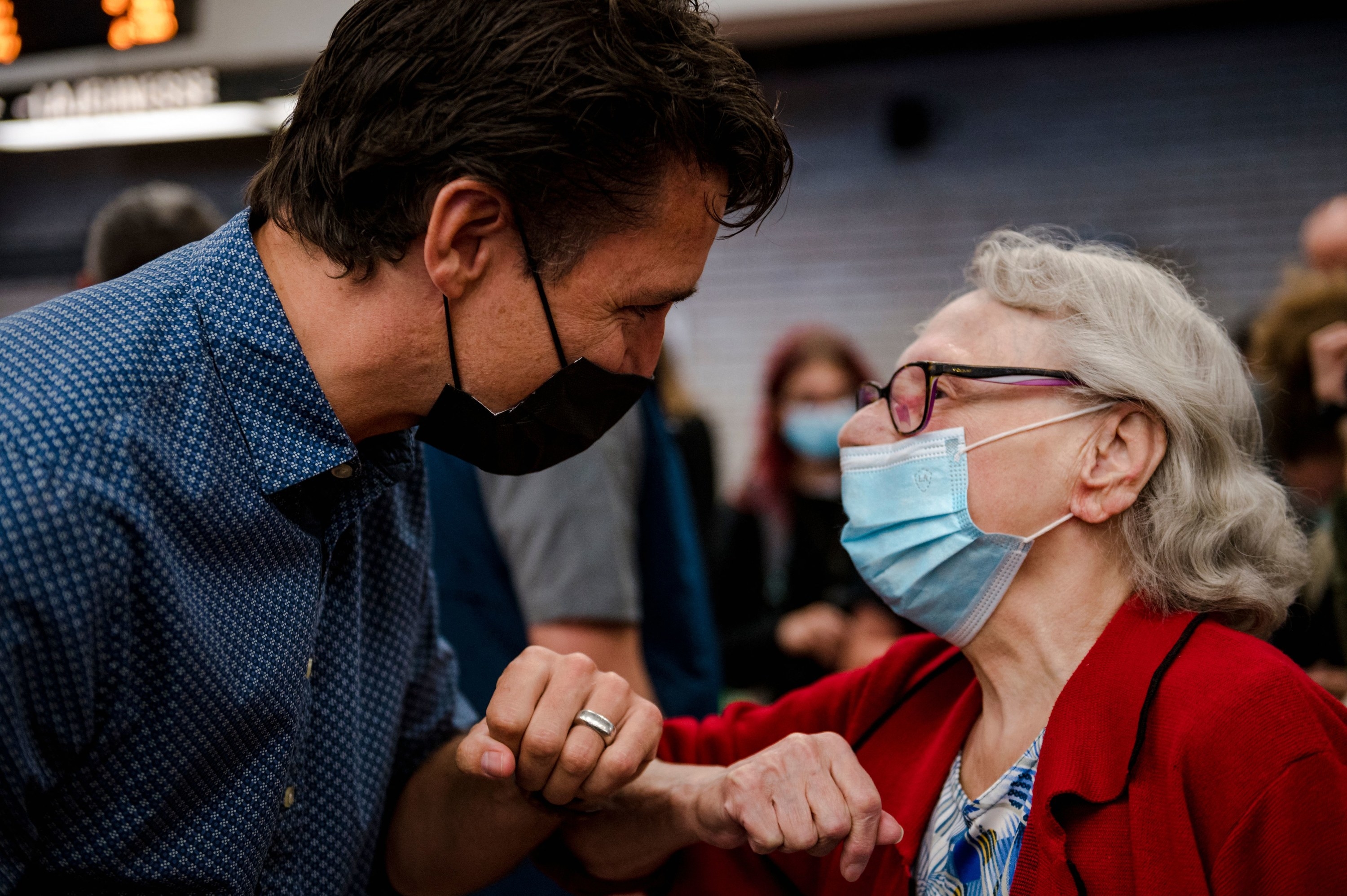 Justin greeting an older person by bumping elbows