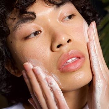 a model putting the dew water cleanser on their face
