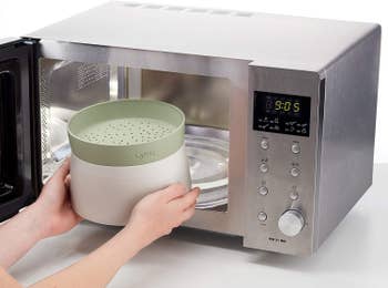 hand putting the green rice cooker into a microwave