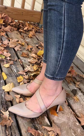 a reviewer wearing the pointed-toe pumps in tan 