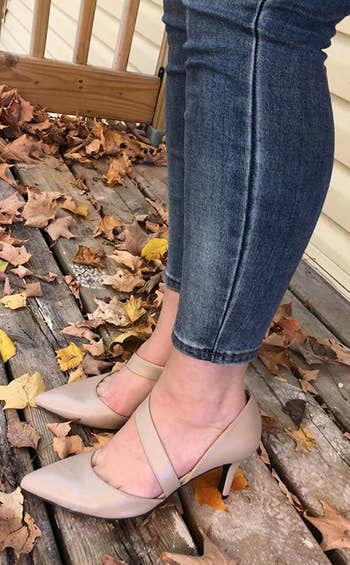 a reviewer wearing the pointed-toe pumps in tan 