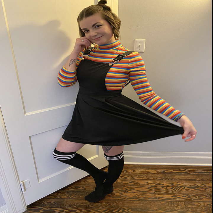 a reviewer wearing the turtleneck in multi colored with a black dress