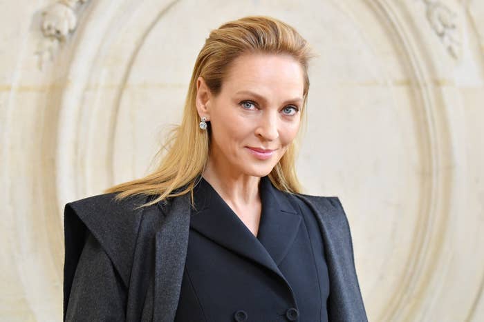 Uma Thurman poses for a photo while wearing a coat over a coat