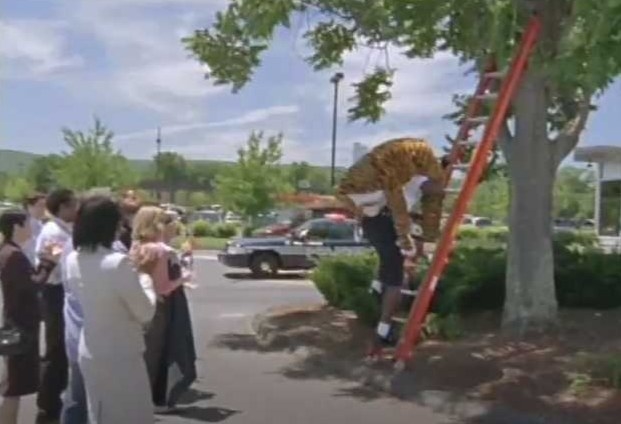 Shaq carries a mascot down a ladder.