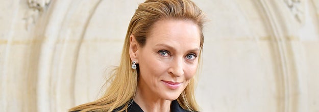 Uma Thurman poses for a photo while wearing a coat over a coat