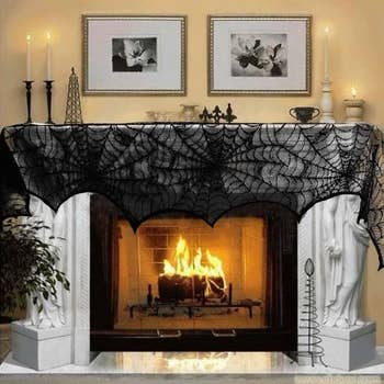 fireplace with black lacey cobweb-style decoration draped across the mantel