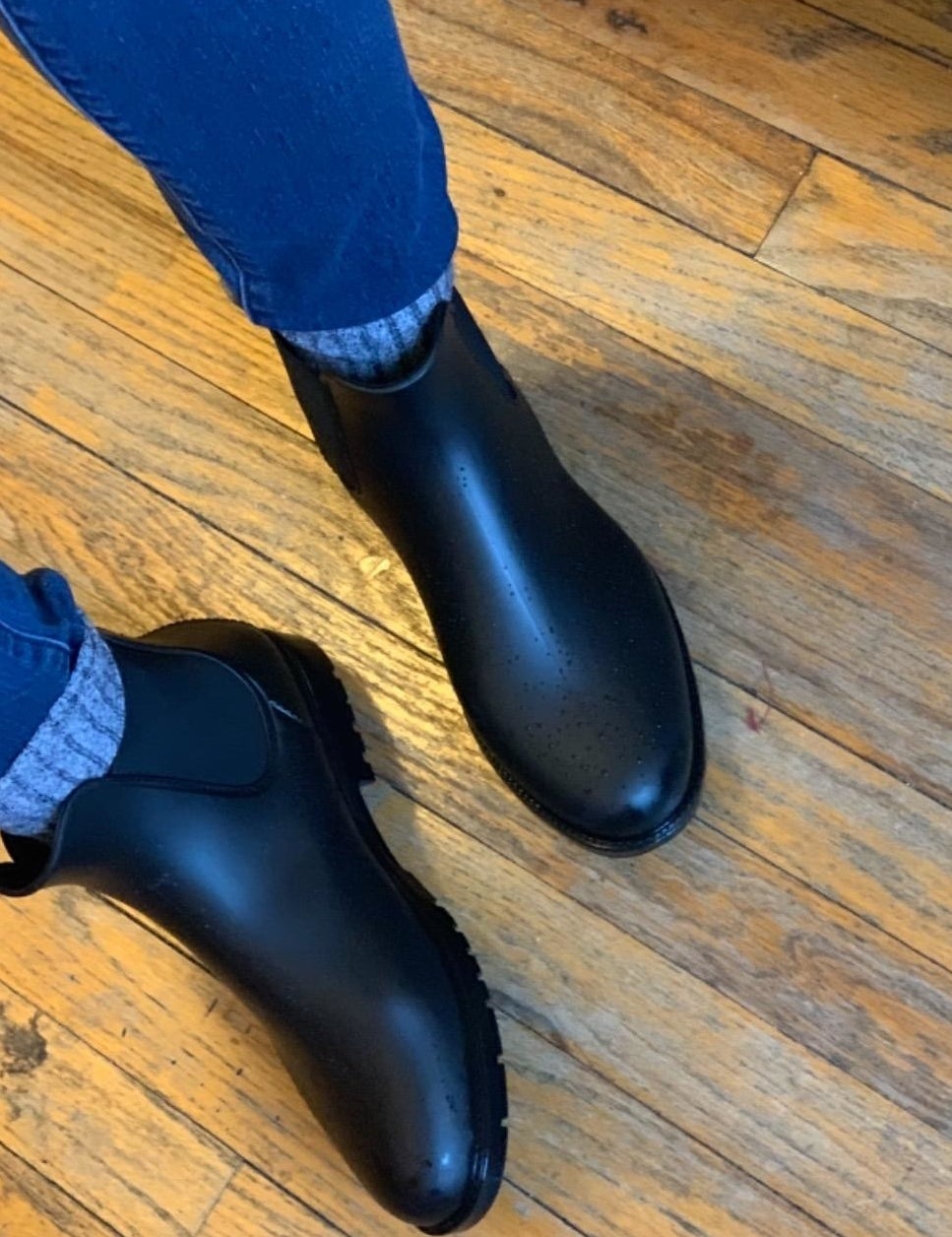 a reviewer photo of someone wearing the boots with thick gray socks and jeans 