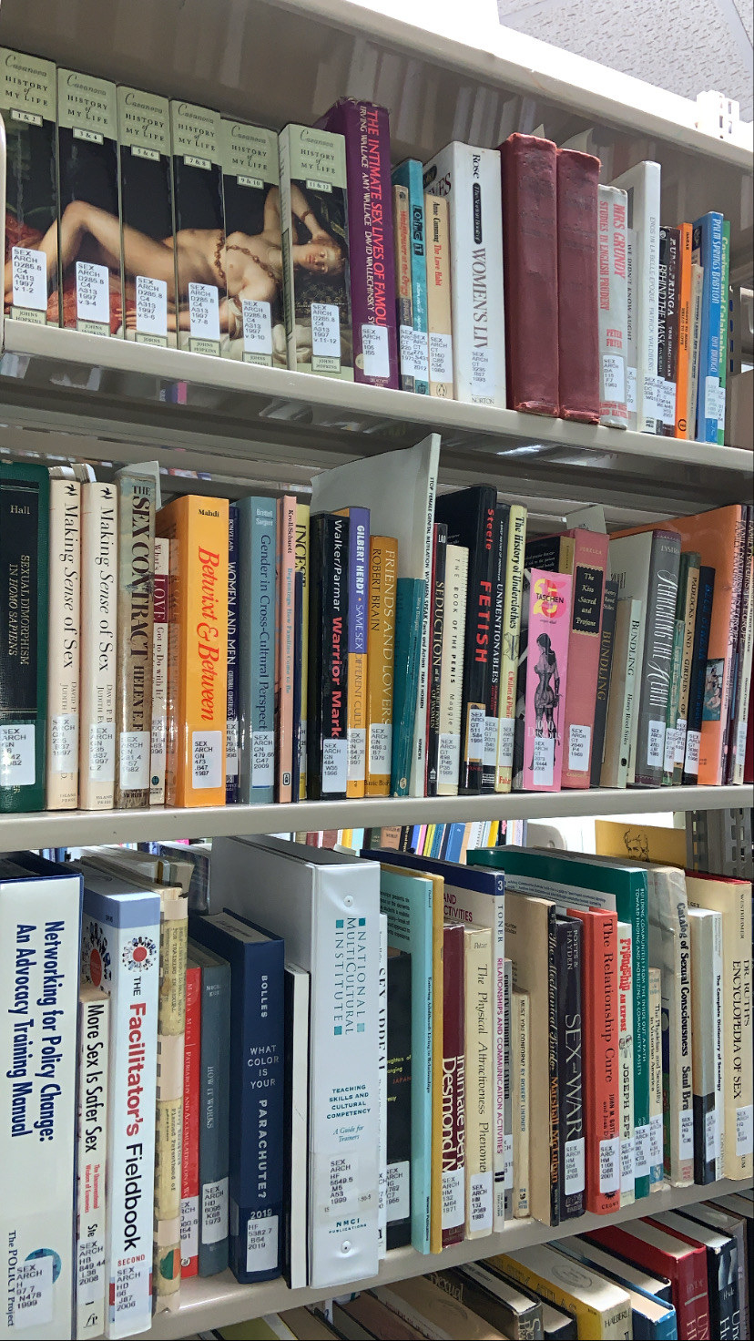 Human sexuality books on shelves inside of a library