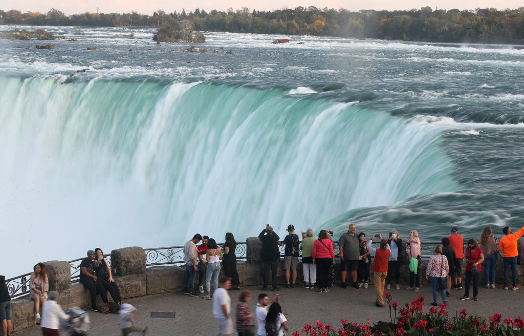 People looking and photographing the view of Niagara Falls.