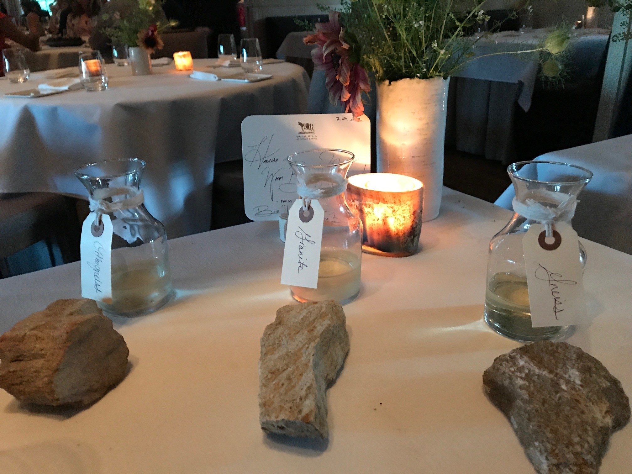 Three carafes of white wine with rocks depicting the type of soil they are grown in