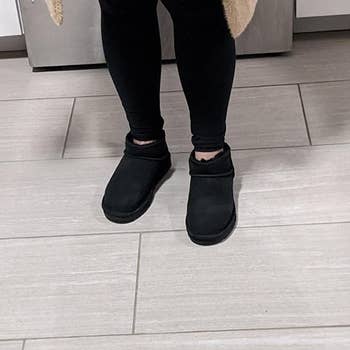 a reviewer wearing the boots in black with black leggings 