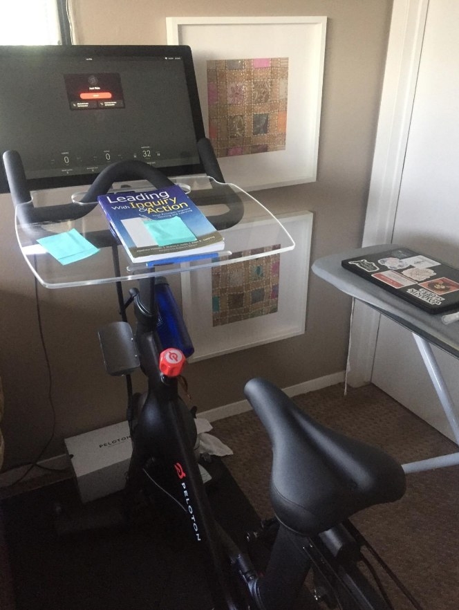Acrylic tray on Peloton workout bike with book on top