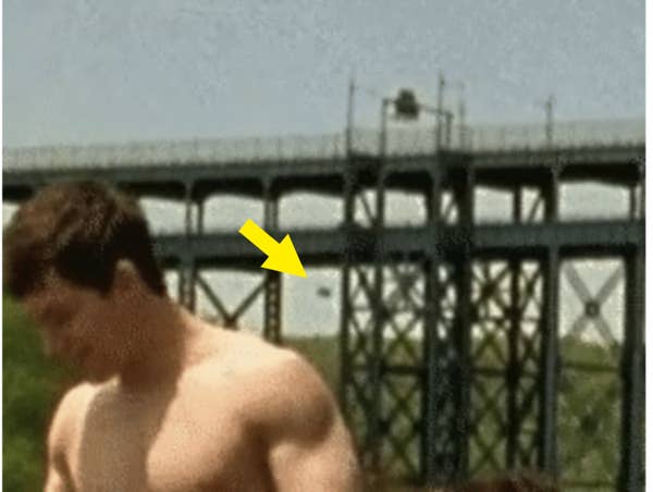 A figure falls off a bridge