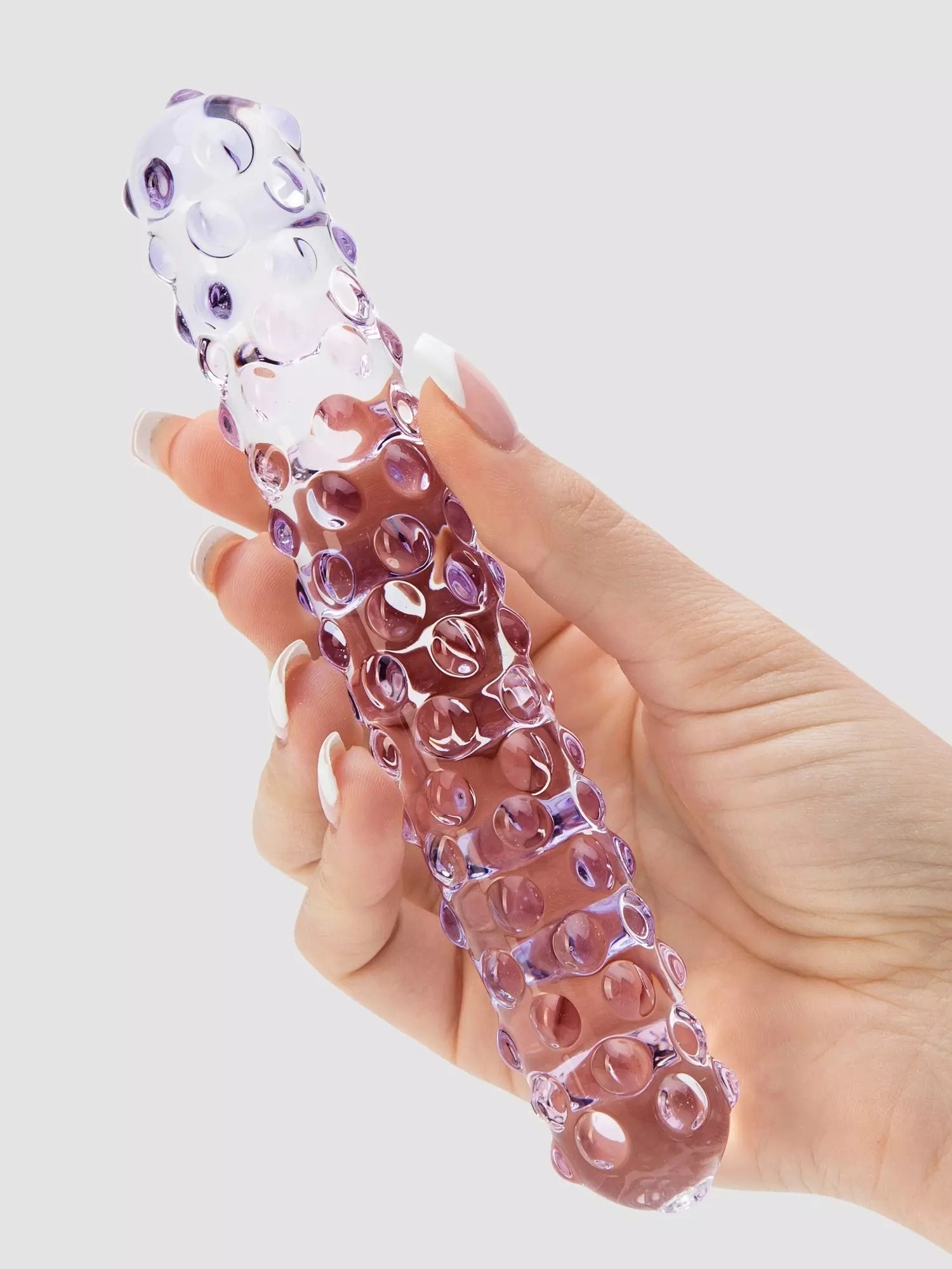hand holding cylindrical transparent toy