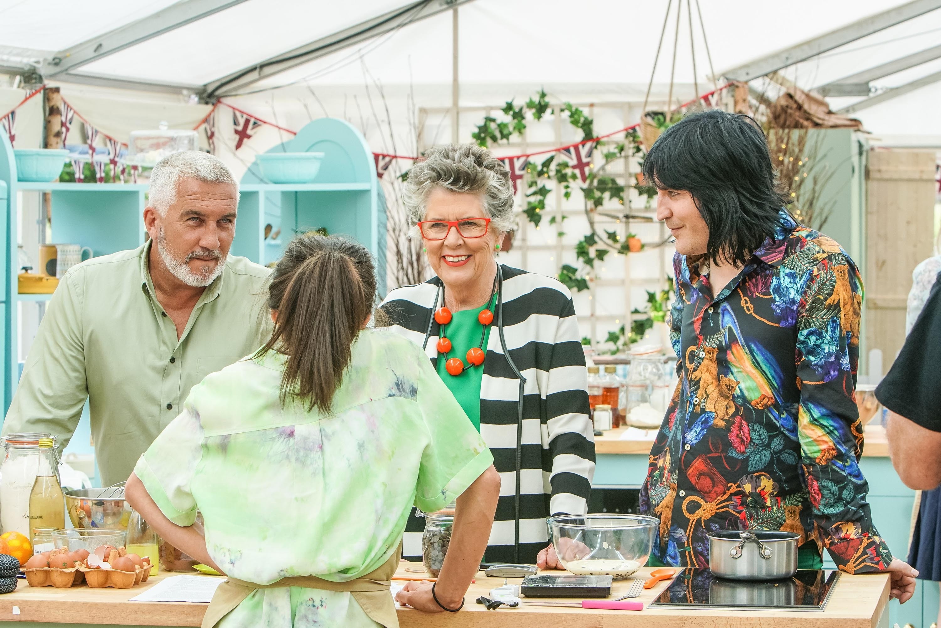 Paul Hollywood, Mary Berry, and Noel Fielding chatting with a contestant.