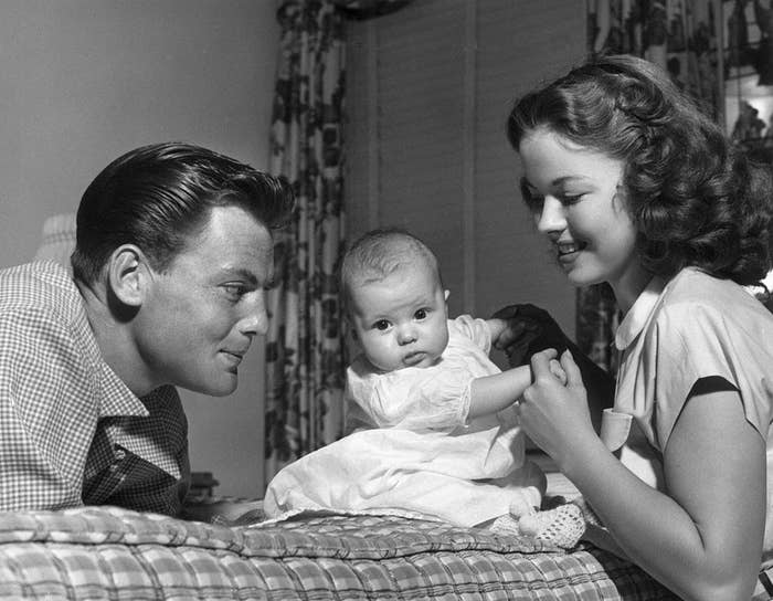 black and white photo of shirley temple, her husband and baby