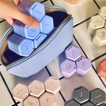 hand placing the magnetized containers inside a beauty bag