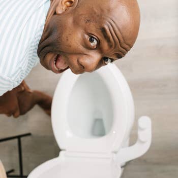 model making a funny face while leaning over the toilet seat