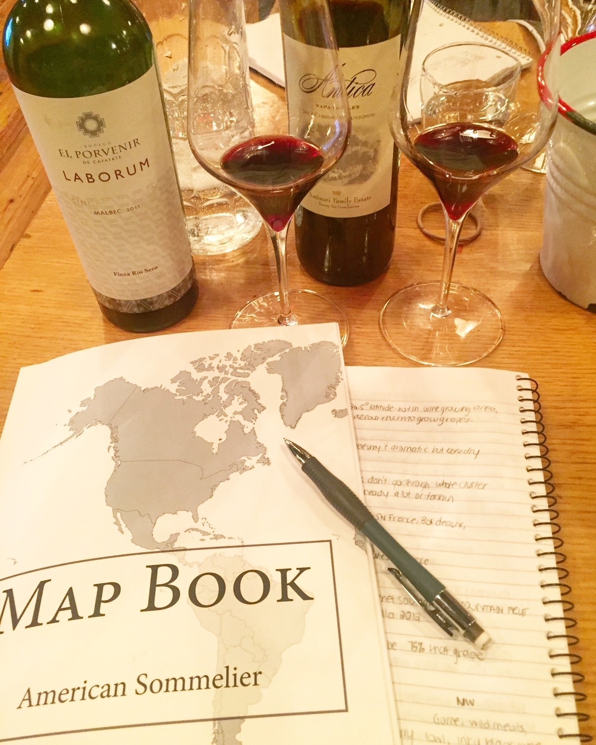 Me taking a wine class with a map book and two glasses