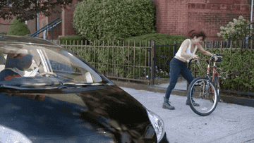 Woman angrily throwing bike to the ground