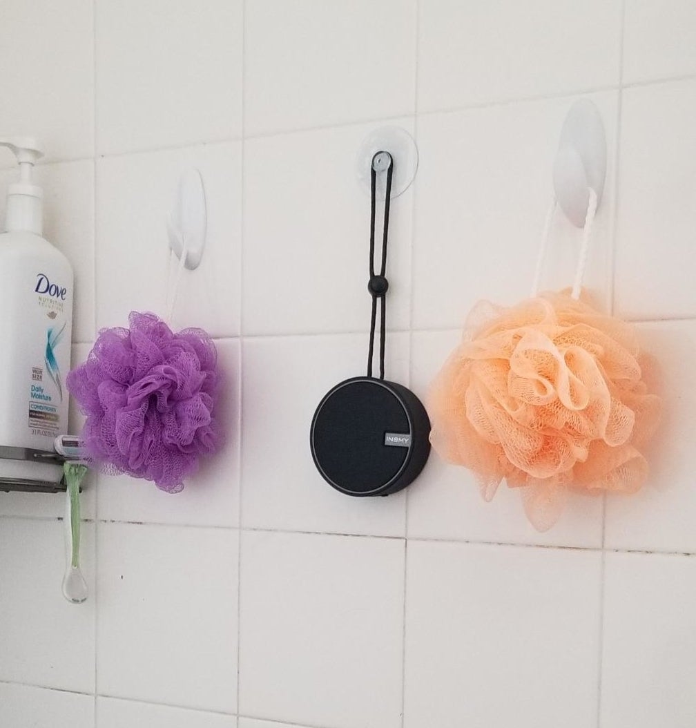 Reviewer photo of the black shower speaker hanging from a suction cup hook