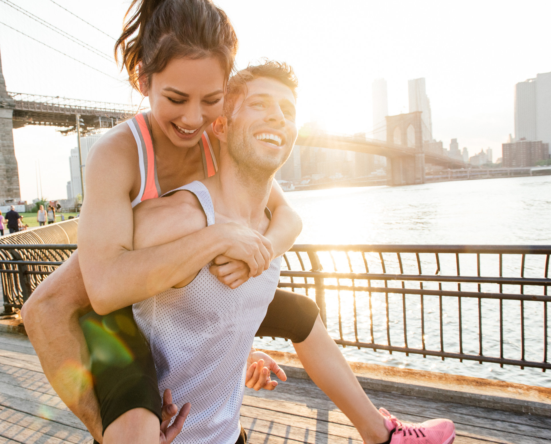 A guy giving his girlfriend a piggyback ride as they exercise