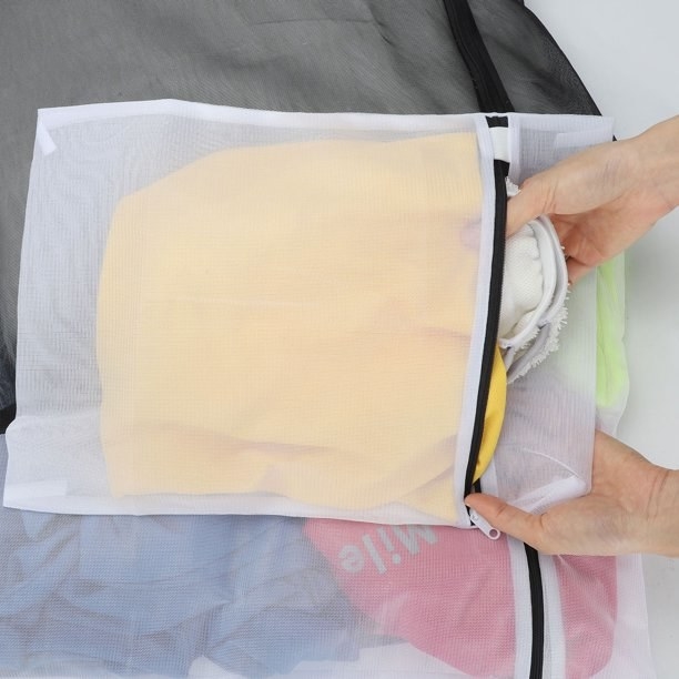 a person putting their delicates into a mesh bag