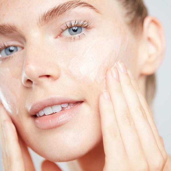 Person applying Papaya Enzyme Peel to their face with hands