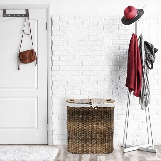 A laundry hamper against a white brick wall