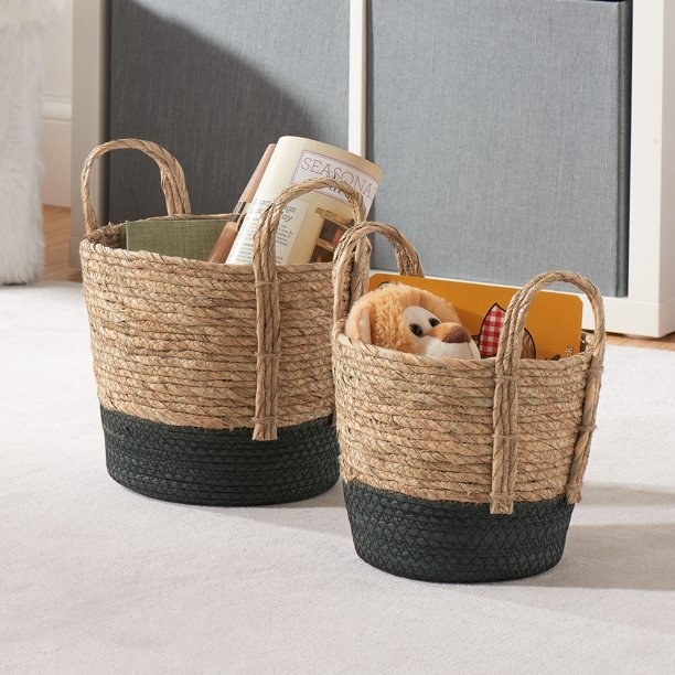 The storage baskets with black bottoms holding toys in a living room