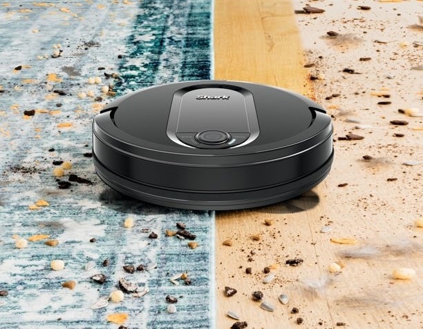 The robot vacuum cleaning a carpeted surfaces as well as a hardwood floor