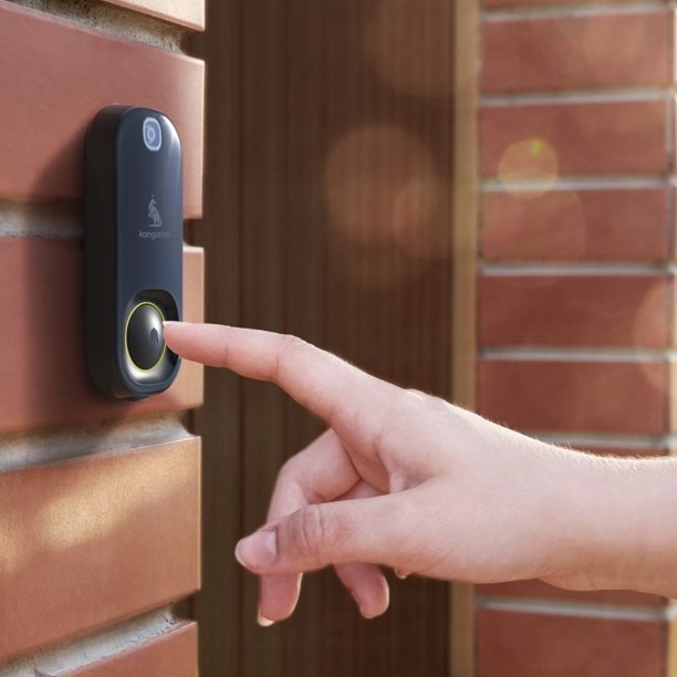A model pressing the doorbell outside a front door