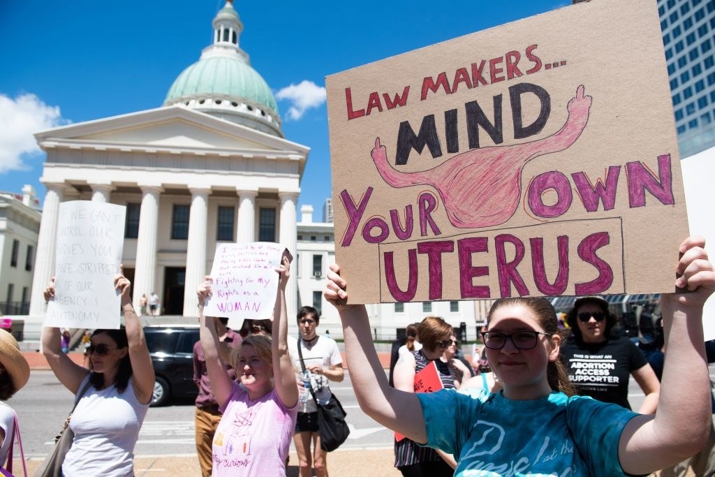 protest sign saying &quot;law makers, mind your own uterus&quot;