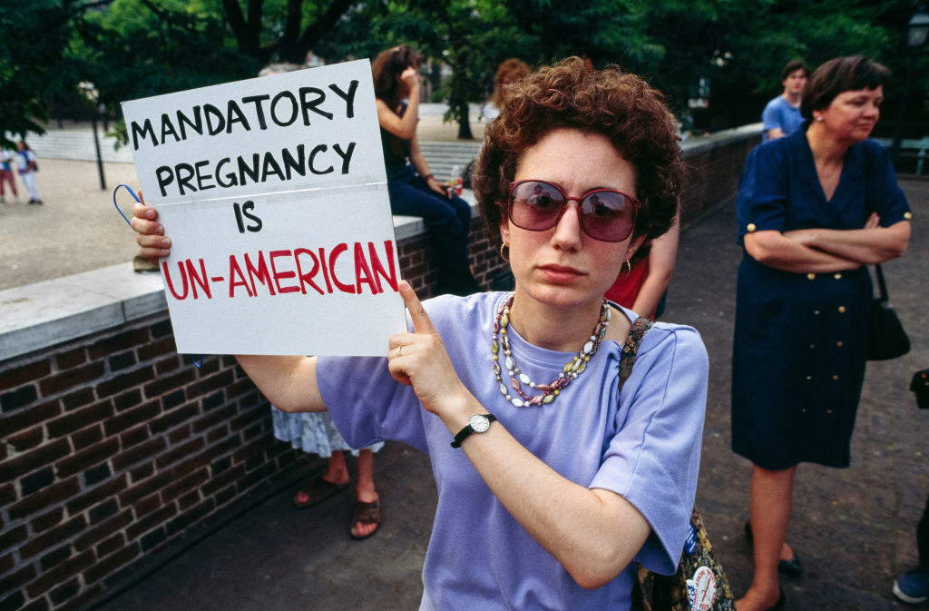 woman holding sign saying &quot;mandatory pregnancy is un-american&quot;