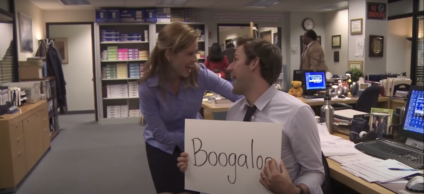 A man holding a board that says &quot;Boogaloo&quot; with a woman beside him