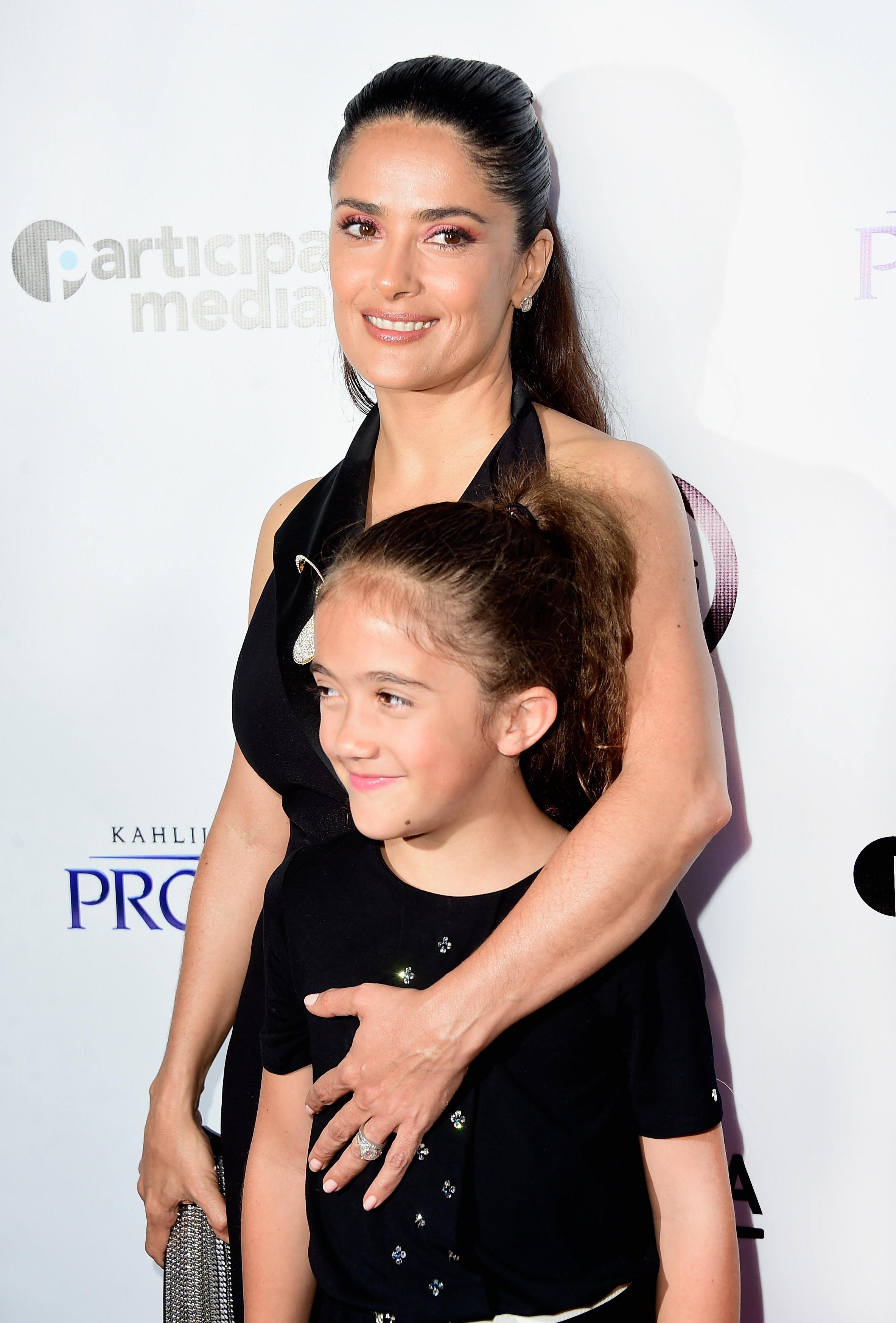 Salma puts her arm around a young Valentina at an event