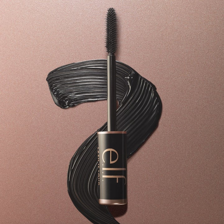 A tube of mascara with a black swatch in the background