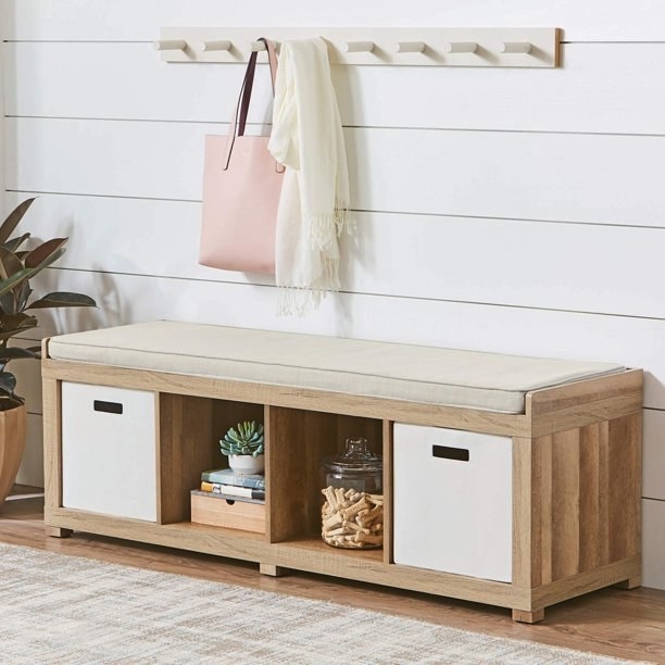 A tan bench with four storage compartments